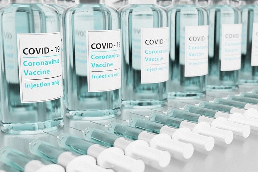 Vials of COVID-19 vaccine and needles n a row