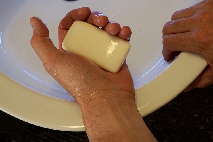 Soap in man's hand over wash basin